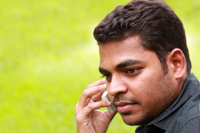 Man talking on a cell phone with grass in the background